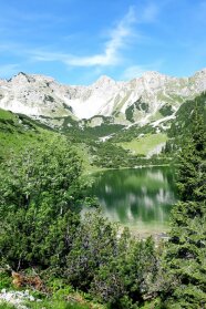 Berglandschaft mit See im Vordergrund.