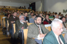 Zuhörer sitzen in einem noch hinten ansteigendem Hörsaal.