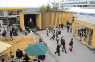 Ausstellungsgelände des Zentral-Landwirtschaftsfests 2012 in München. Links im Bild ist ein Gatter mit einem Holzzaun, mittig der hölzerne proHolz Pavillion und rechts im Bild ein weiteres Gebäude aus Holz und Glas zu sehen. Im Hintergrund befinden sich große Festzelte.