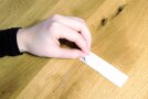 Person faltet Stoffrechteck in die Mitte.