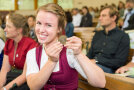 Junge Frau im Dirndl päsentiert stolz ihre Medaille