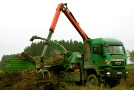 Ein LKW mit einem aufgebauten Holzhacker bei der Arbeit. 