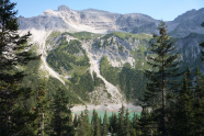 Panoramablick auf einen Bergsee mit Wald im Hochgebirge.