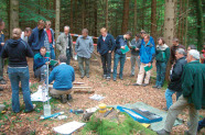 Personengruppe mit verschiedenen Gerätschaften im Wald