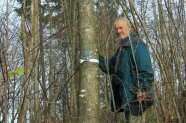 Mann steht neben einem Baum