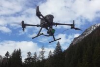 Fliegende Drohne vor einer Berglandschaft