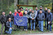 Gruppe Personen mit einen blauen Flagge auf der ein Kreis aus Sternen zu sehen ist, in dessen Mitte "Life" steht.