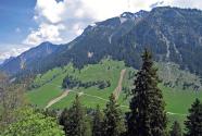 Bergflanke mit Rutschungen auf den Grünflächen, unterhalb des Bergwaldes. 