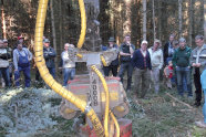 Gruppe Menschen im Wald, die ein Harvesteraggregat betrachten.