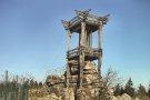 Ein Holzturm steht in der Landschaft