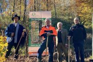 Die Jury im Wald vor einem Banner zum Baum des Jahres