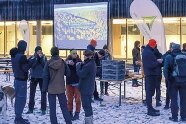 Eine Gruppe von jungen Studenten im Schnee vor der Open Air Leinwand.