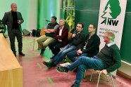 Referenten sitzen vor einem Publikum und beantworten Fragen.