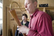 Ein Mann und eine Frau spielen auf einem holzernen Musikintrument 